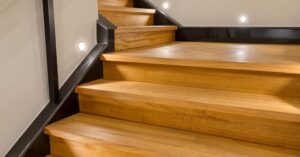 A set of modern wooden stairs with black trim.