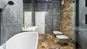 Contemporary bathroom interior with bathtub, shower, bidet, and sink showcasing a modern luxury vinyl tile bathroom floor.
